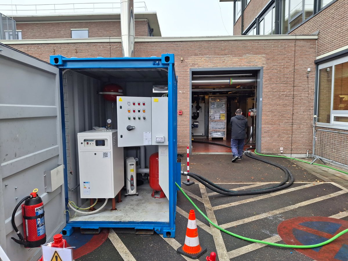 Binnenkant van een container met de KH 100 mobiele ketel van Andrews Sykes, aangesloten op het bestaande warmwatersysteem via tijdelijke leidingen.