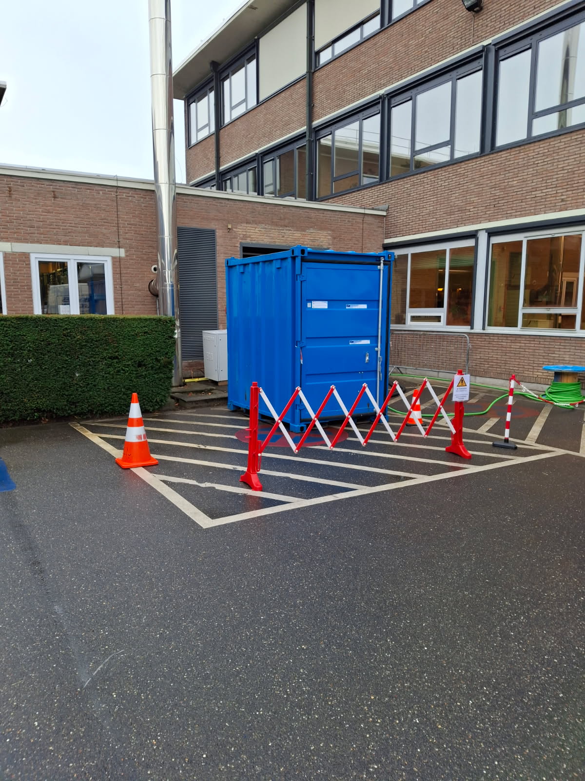 Container bleu contenant une chaufferie mobile installée sur le parking d’une maison de repos, solution temporaire Andrews Sykes Climat Location.